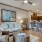 Model living room at our apartments for rent in Magnolia, featuring wood grain floor paneling and a view of the kitchen.