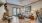 Model living room at our apartments for rent in Magnolia, featuring wood grain floor paneling and windows with blinds.