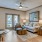Model living room at Alders Magnolia 55 plus community, featuring wood grain flooring and a view of the balcony.