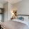 Model bedroom at our apartments for rent in Magnolia, featuring carpeted flooring and a view of the closet.
